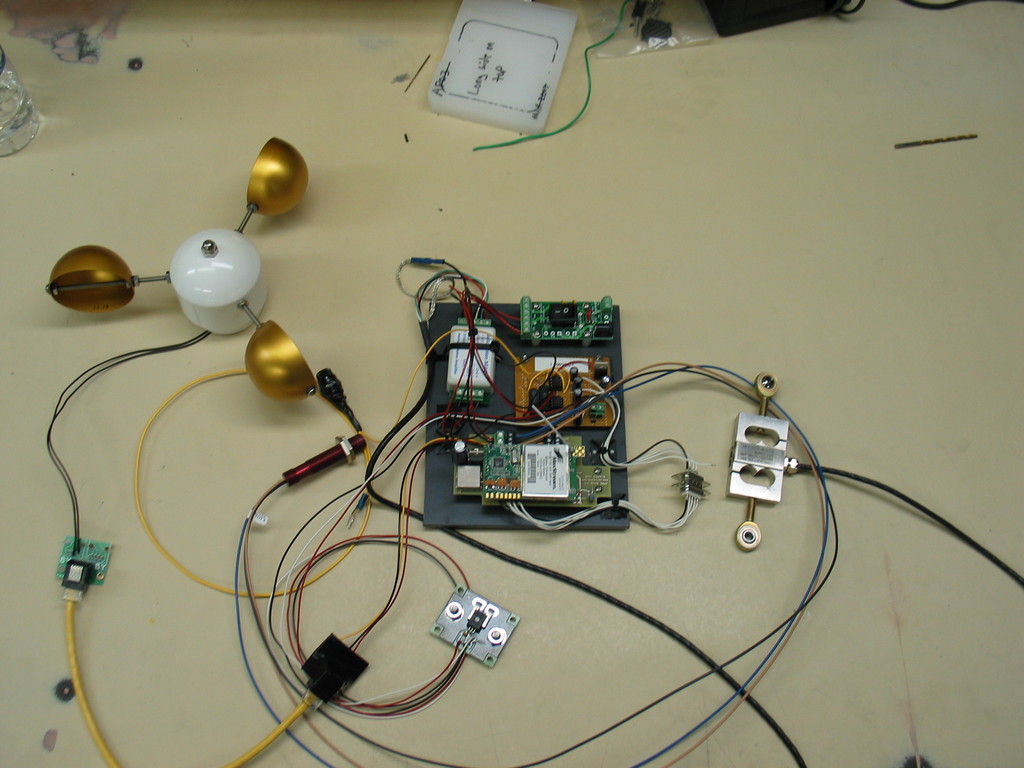 Prototype on bench. Includes anemometer, RPM sensor, load cell, current sensor, voltage inputs, and wireless connectivity. All hand assembled and quite a mess.