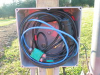 Junction box at the base of the tower. The big black wires are the 24 volt generator output. The small black and blue cables are for the anemometers and wind vane. The green block is an 8Y splitter.