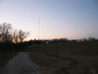 Overview of the site looking west. The bright dot in the distance is the sign lite. You can see the disturbed soil from the trench to the dorms.