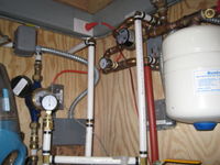 Fuzzy picture of flat plate heat exchanger, expansion tank, glycol circulation pump, water meter, and water pressure gauge.