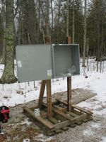 Weather station enclosure constructed from scrap materials. The box came from a scap metal dumpster in Iowa. The pallet and the slightly burned 2x4's were found on site. A chainsaw was used to precisely mitre cut everything.