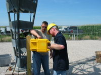 James of APRS World shows Patrick of Tower Tech the data logger installation steps.