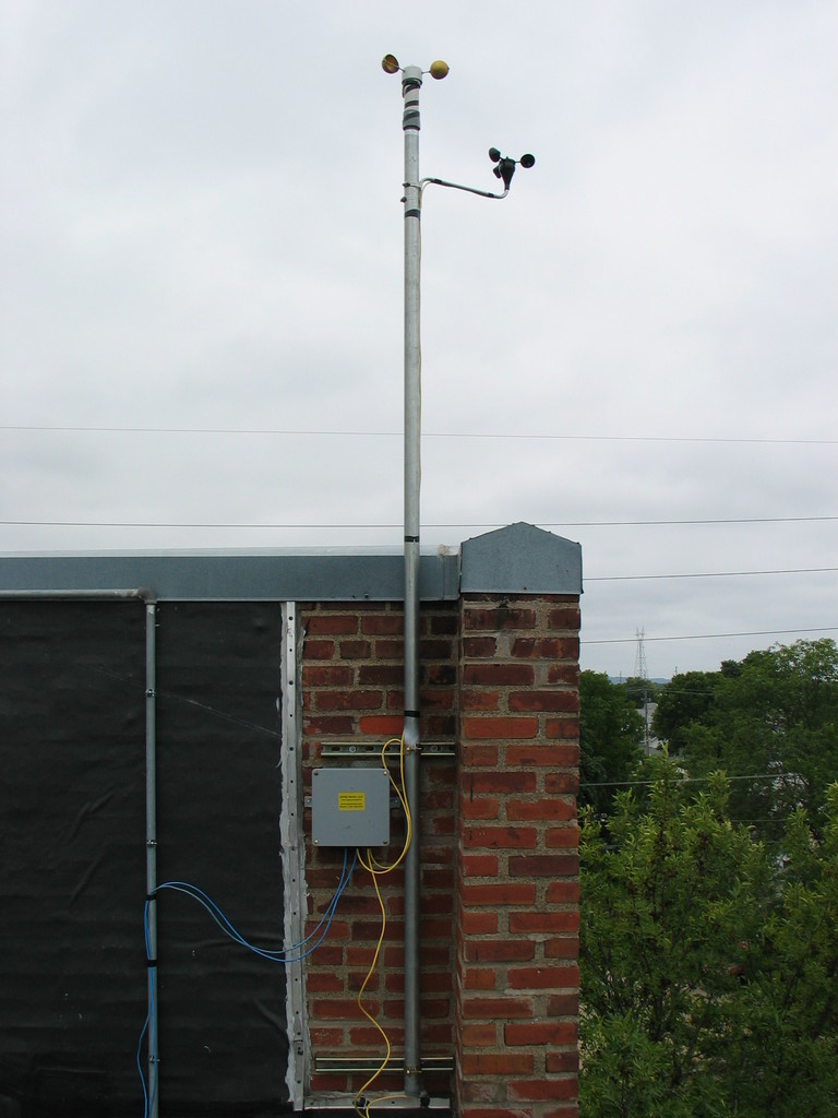  Mast mounted to building facade. The mast is 1.5" galvenized steel schedule 40 pipe. Uni-strut and strut clamps hold the pipe to the building. Wedge anchors were used to attach the strut to the brick.
