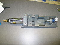 Pneumatic PVC drill. The air cylinder on the left pushes the PVC pipe into the v-block. The springs behind the v-block compress and the PVC pipe feeds into the 22,000 RPM drill bit. Instant perfectly aligned hole.