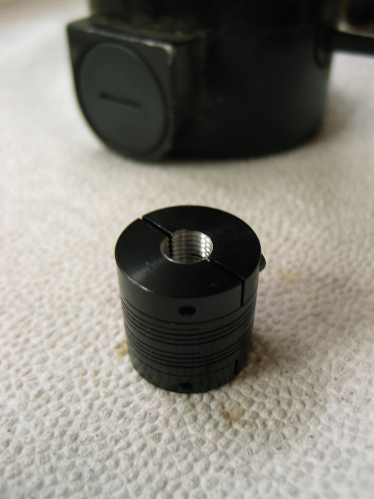 A helical beam coupler is used to attach the encoder shaft to the motor shaft. It replaces a 3/8"-24 nut that holds the worm on to the motor shaft. I bored and tapped one side of the coupler to take the place of the original nut. 