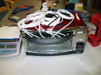 $50 toaster oven that has been outfitted with a PID temperature controller. Used for drying parts and curring potting compound. 0.1 gram counting scale partially visible on the left.