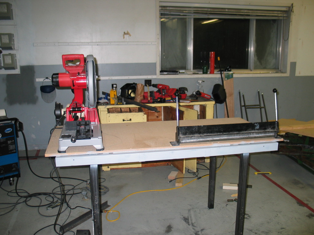 Currently there is a bench grinder, drill press, and vise also on the table. Eventually an outfeed and stop for the dry cut saw will be fabricated. Note the high quality rattle can primer. I got bored and sick of primering before getting to the legs. Fortunately they still have tons of metal protectant left of them...