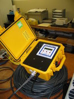 Extremely rugged cable grips are used to prevent the underwater cable from being pulled out of the enclosure. The yellow Pelican case has clamps on its back to allow it to be attached to the same pole that supports the solar panel.