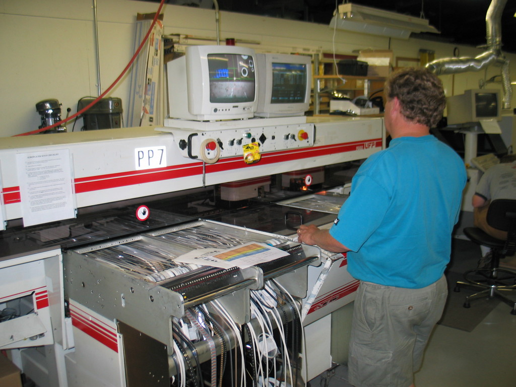 Steve Brown, owner of Wintech Electronics, programs one of the pick and place machines for the Wind Monitor II. For the first few boards we just had it place passives and others reeled parts that were already on the machine. The other parts were hand placed.