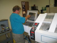 Steve washes the remaining solder paste residue of the stencil. The same wash machine is used for cleaning the water wash flux off the boards. The boards are then dried with compressed air and/or a low temperature oven.